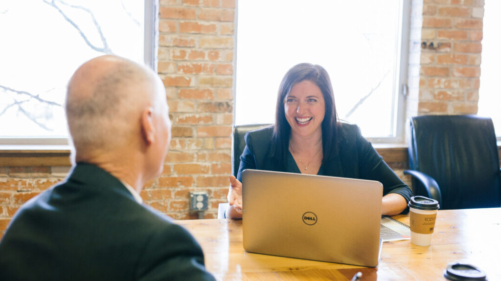 Female adviser speaking with a middle-aged client at a desk about wealth planning