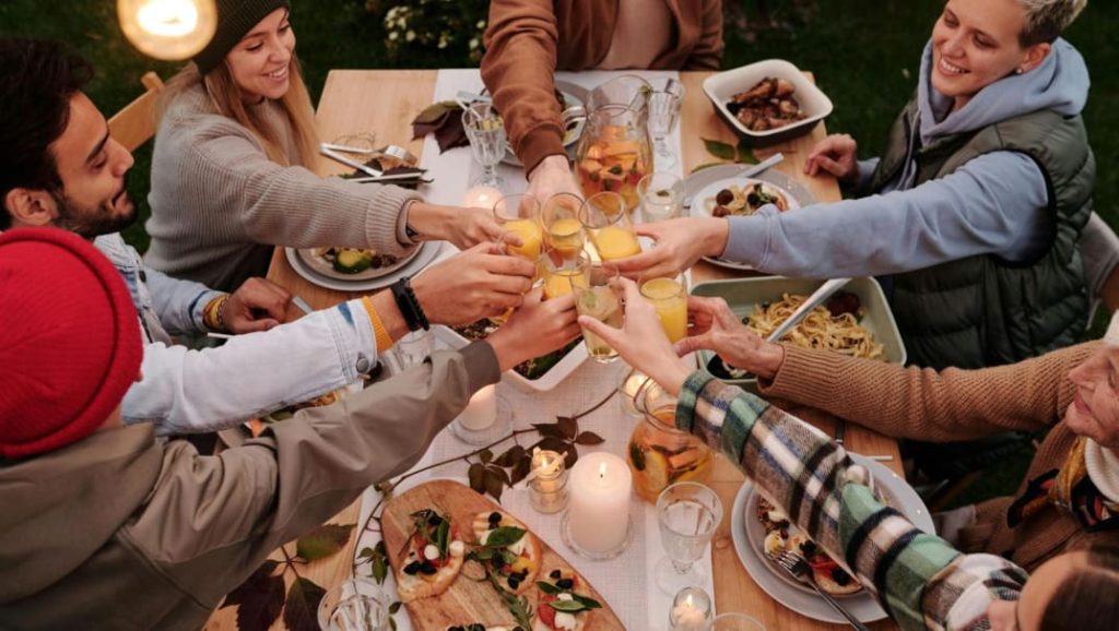 Family sitting together sharing a meal and enjoying their lifestyle, representing long-term life goals and financial planning for the future