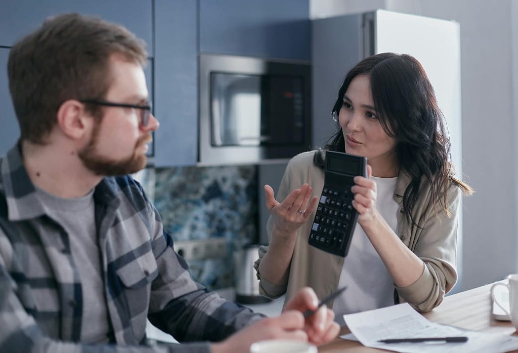 Couple reviewing expenses and calculating their household budget
