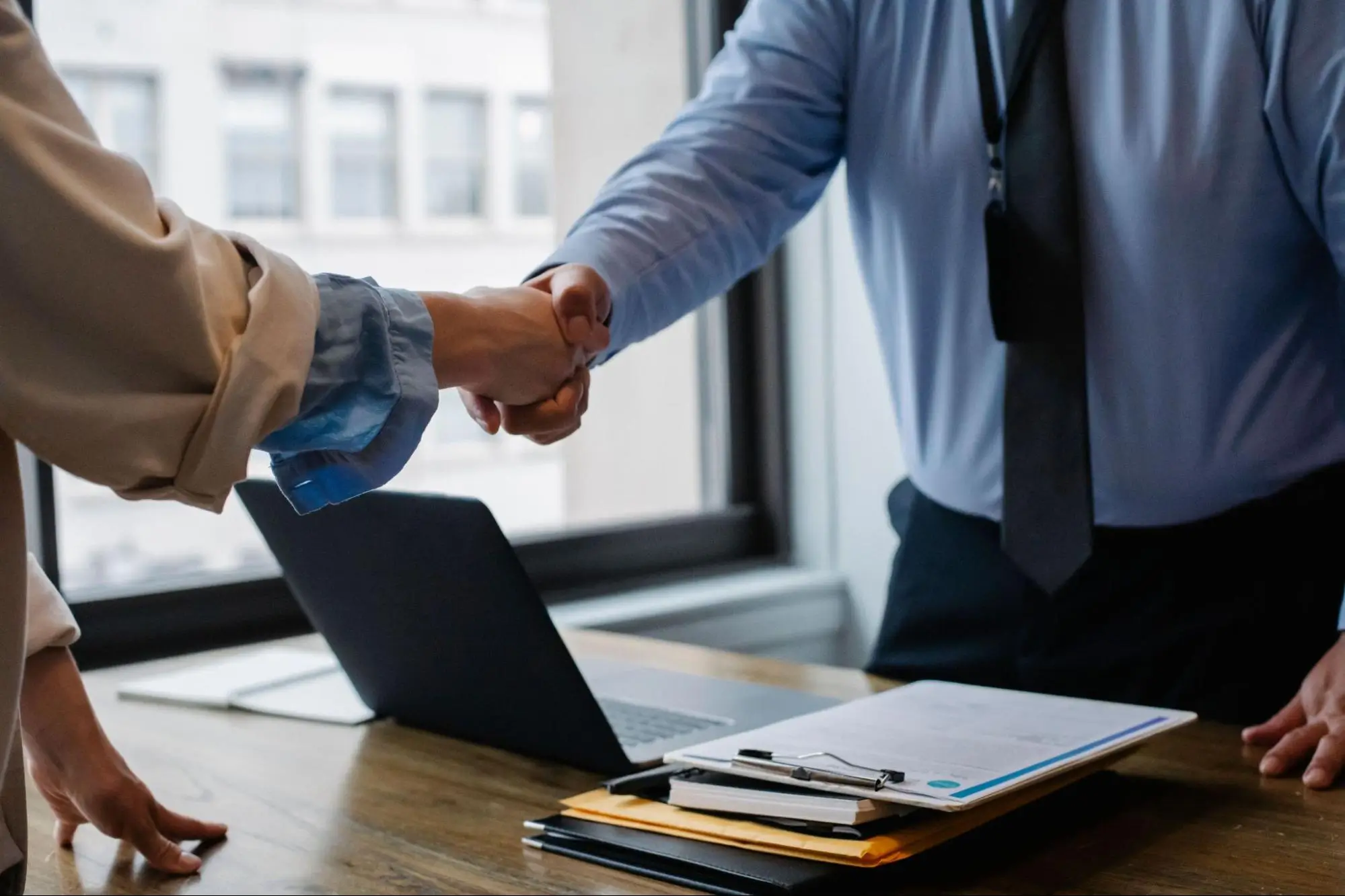 Client shaking hands with a financial advisor symbolising secure financial decisions in a trusted, professional environment.