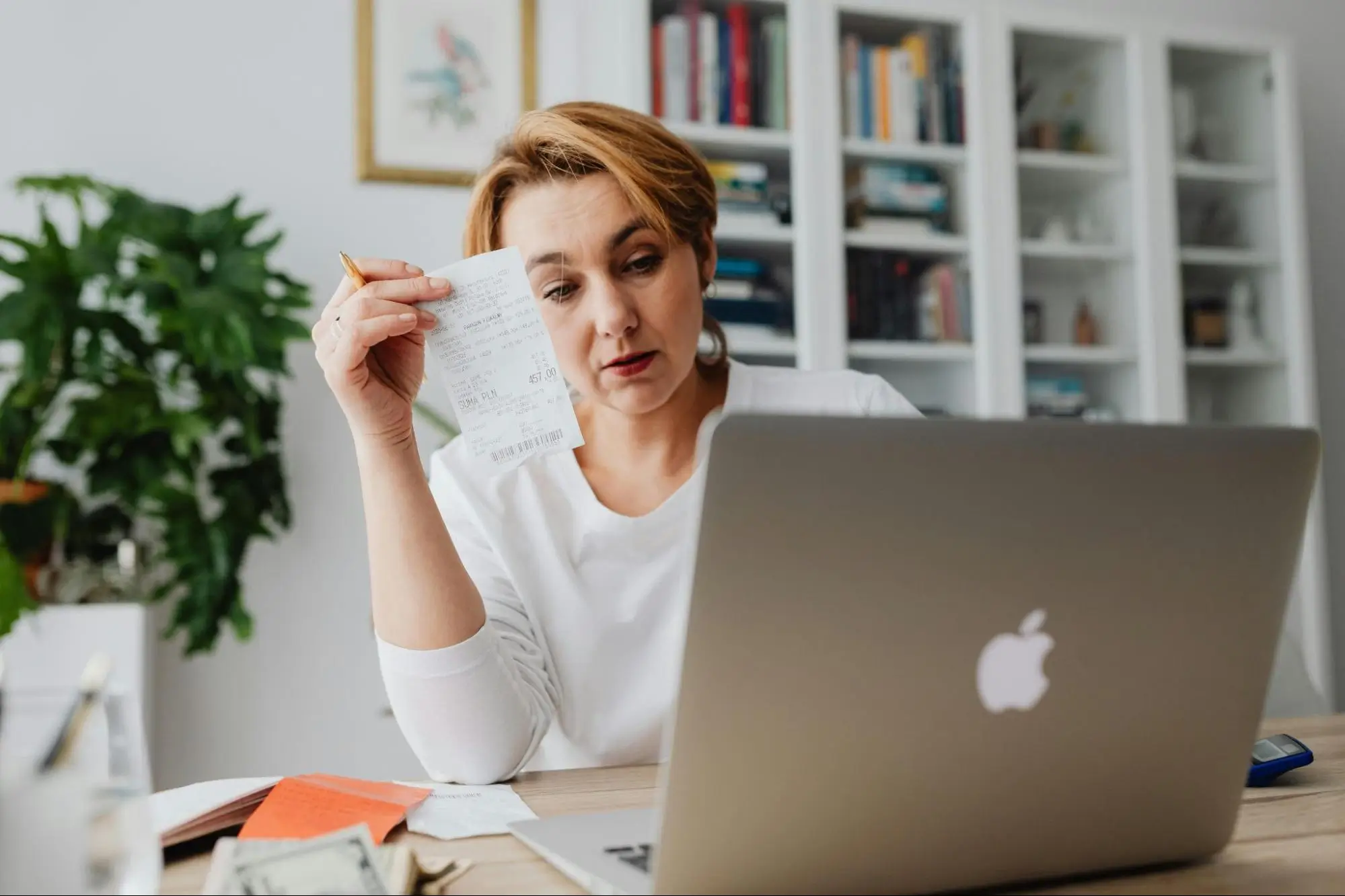 Woman reviewing documents and calculating receipts, focusing on financial decisions and next steps.